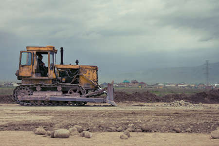 Yellow bulldozer on tracks at the mountain road constructionの写真素材