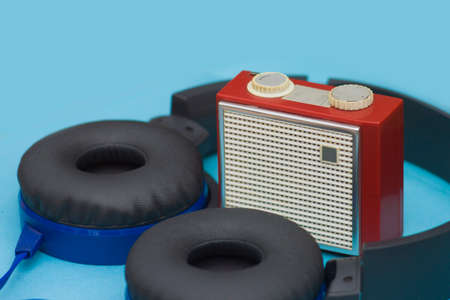 Old red radio with blue headphones on delicate blue backgroundの写真素材
