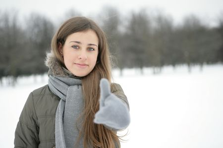 Girl in the park in winter. Hand. Sign okの写真素材