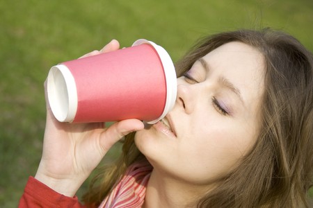 Female in a park drinking coffee 