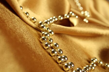 Background of gold cloth on which lay the golden beads の写真素材