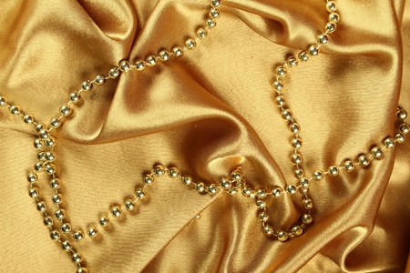 Background of gold cloth on which lay the golden beads の写真素材