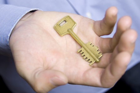 Keys to the house in the palm of a young man in a blue shirtの写真素材