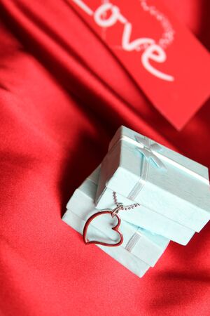 A red silk greeting card and gift boxes with silver decoration の写真素材