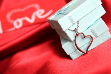 A red silk greeting card and gift boxes with silver decoration の写真素材