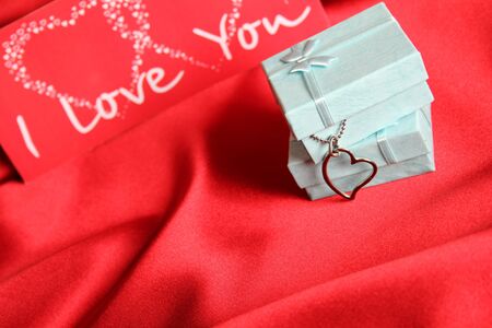 A red silk greeting card and gift boxes with silver decoration の写真素材
