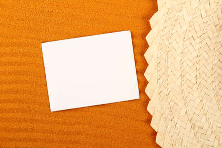 Close-up on the yellow sand lie hat and paperの写真素材