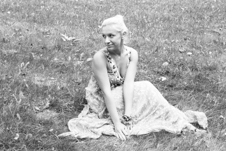 Young attractive woman sitting in a park on the grassの写真素材