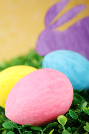 Close-up rabbit with colorful Easter eggs on green grassの写真素材