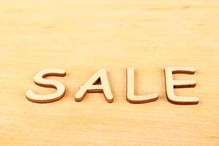 Close-up wooden letters  sale  on a wooden background