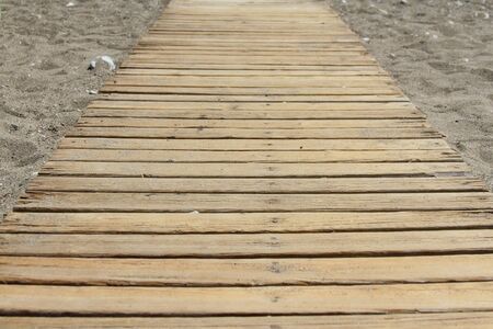 Wooden pier is passes through the rocky beachの写真素材