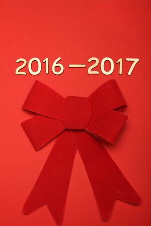 Wooden 2016 - 2017. New year text on plank wood. Red velvet bow
