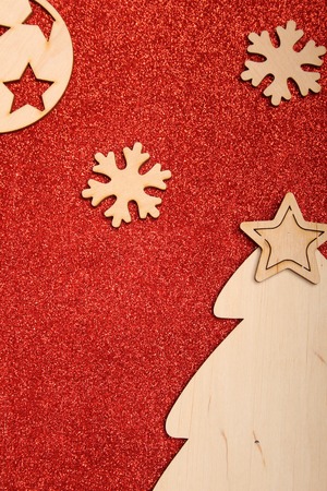Christmas card on a red background wooden silhouettes of snowflakes, Christmas trees and a Christmas ballの写真素材