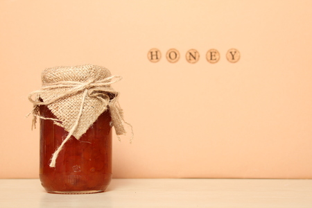 A honey can near the wall on which is written the word honeyの写真素材