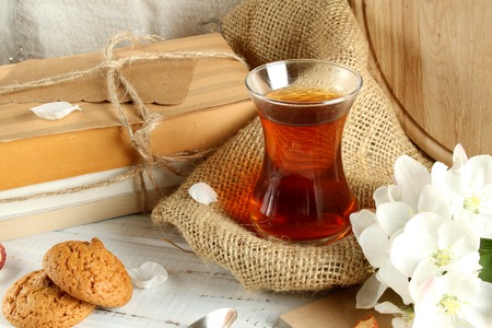 Tea with cookies, dried apples and old books on the slot.