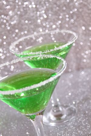 Two glasses with green alcoholic drinks. Background silver shinyの写真素材