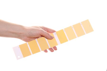 Woman hand holds a yellow color palette. Isolated on white background