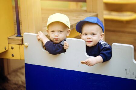 2 twin brothers play together at the playground, 1-2 years oldの写真素材