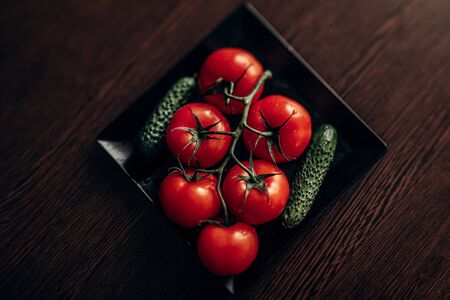 bunch of juicy, red tomato close-up on a black plate. Flat up. Top viewの写真素材