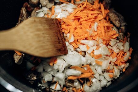 Onions with carrots are fried. Home cooking. Pilaf with meatの写真素材
