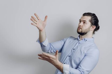 Successful handsome businessman with a beard points to the side.