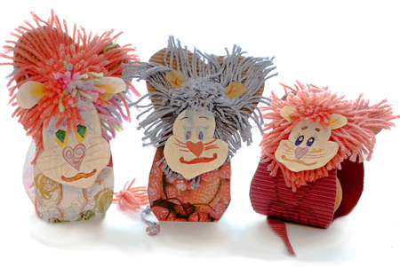 Three homemade cardboard lion of paper and wool thread on a white backgroundの写真素材
