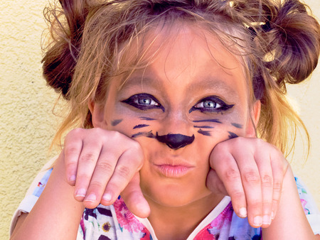 School-age child cat face hands under his head. Wearing animal kitty girl baby game cute feline...