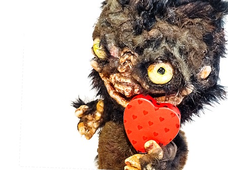 Muzzle monster with fangs, bulging eyes and a huge mouth toy fur and papier mache, the beast faces heartsの写真素材