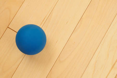 Blue Rubber Racquetball on Hardwood Court Floorの写真素材