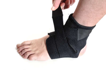 Wrapping a Black Ankle Brace Isolated on Whiteの写真素材