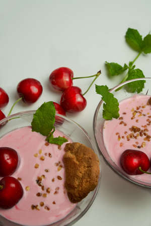 Cherry mousse with cookies, fresh cherries and mint leaves.の写真素材