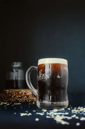 beautiful tall steaming mug with dripping drops, full of dark carbonated drink with lush foam on...