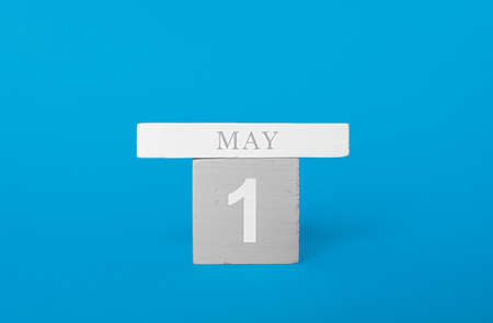Wooden cubes of a calendar with the date may 1 on a blue background.の写真素材