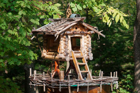 Handmade wooden strange house with stairs for birds and small animals in the middle of the forestの写真素材