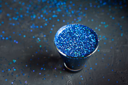 blue shiny stars in a glass on a dark shiny table, top view, holiday cocktailの写真素材