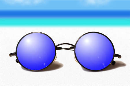 Tinted glasses on white sand against the sea