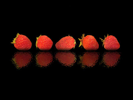 Five berries of a strawberry on a black backgroundの写真素材