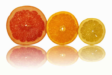 The sliced fruit and their reflection on a white backgroundの写真素材