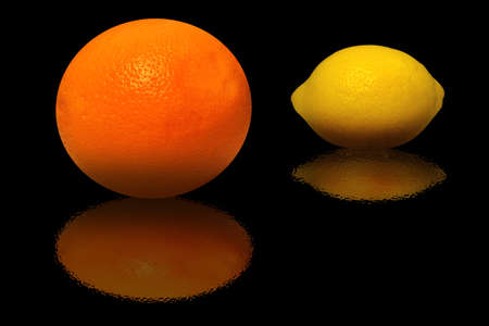 Orange and lemon and their reflection on a black backgroundの写真素材