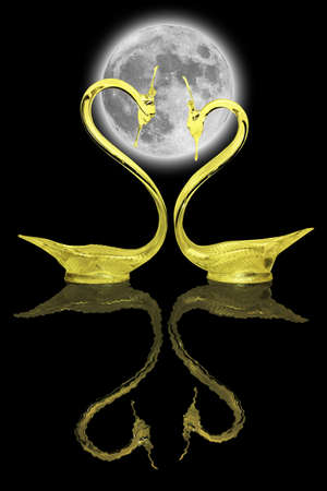Two gold swans and their reflection on a black backgroundの写真素材