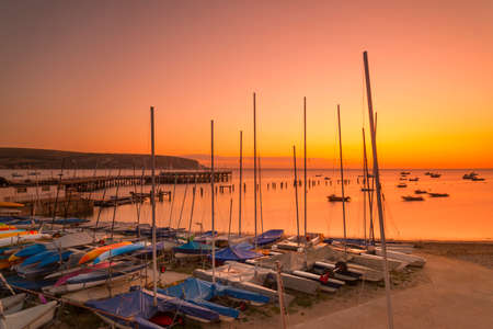Boats, the new and old piers are illuminated by the orange pre-dawnの写真素材