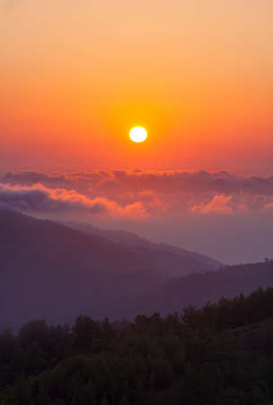 The sun sets above clouds at altitude in the Troodos Montainsの写真素材