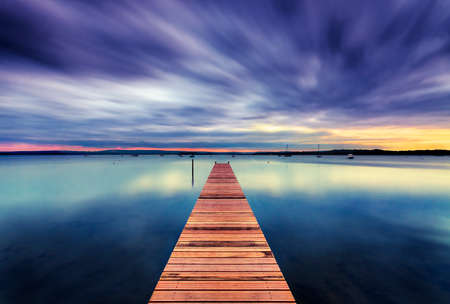 The Sun sets over Poole Harbour in Dorset. Hamworthy pier jettyの写真素材