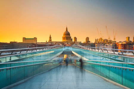 Blurred motion view over the Millennium footbridge looking towards St. Paul's Cathedral at sunsetの写真素材