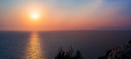 A plane passes ver the sun on its way in to land on Rhodesの写真素材