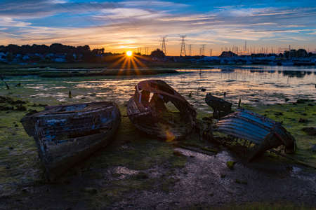 Derelict boats in the backwaters of Holes Bay, Poole Harbour at low tideの写真素材