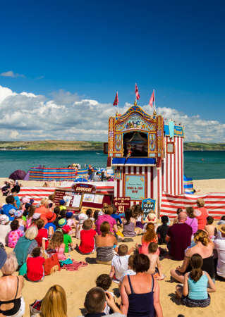 WEYMOUTH, UK - AUGUST 15TH 2017: A Punch and Judy show takes place on the beach at Weymouth in Dorset.のeditorial素材