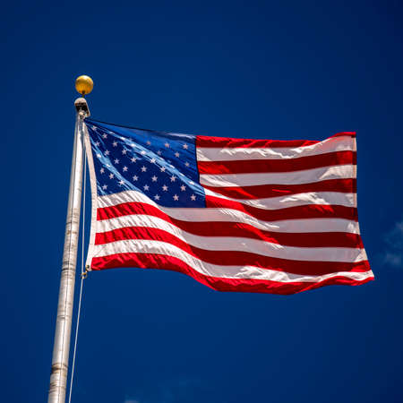 A strong breeze blows the Star Spangled Banner almost horizontalの写真素材
