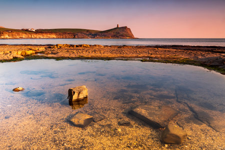Golden hour at Kimmeridge on the Dorset Coast looking across rocks and seaの写真素材