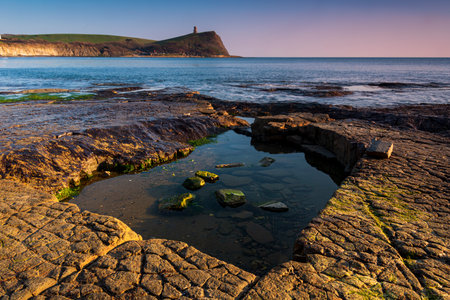 Golden hour at Kimmeridge on the Dorset Coast looking across rocks and seaの写真素材